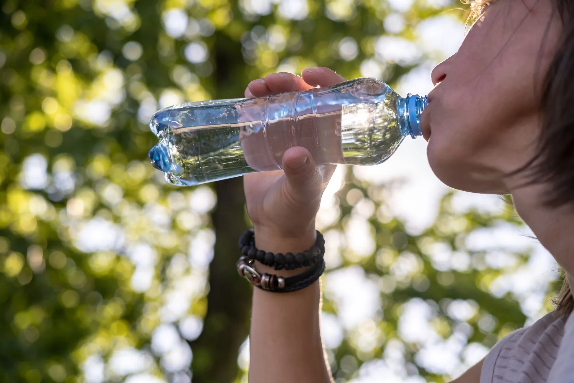 woman-drinks-cool-drinking-water-from-plastic-bottle-hot-day