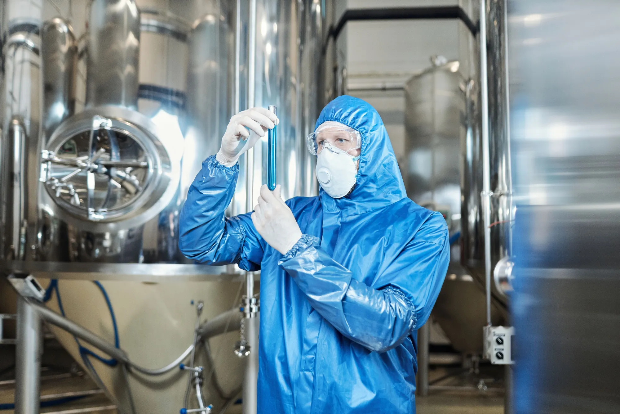 worker-wearing-protective-gear-holding-test-tube-chemical-plant